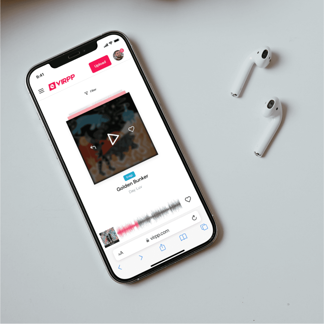 A phone on a table next to earbuds shows the track page with cover art, play button and waveform.