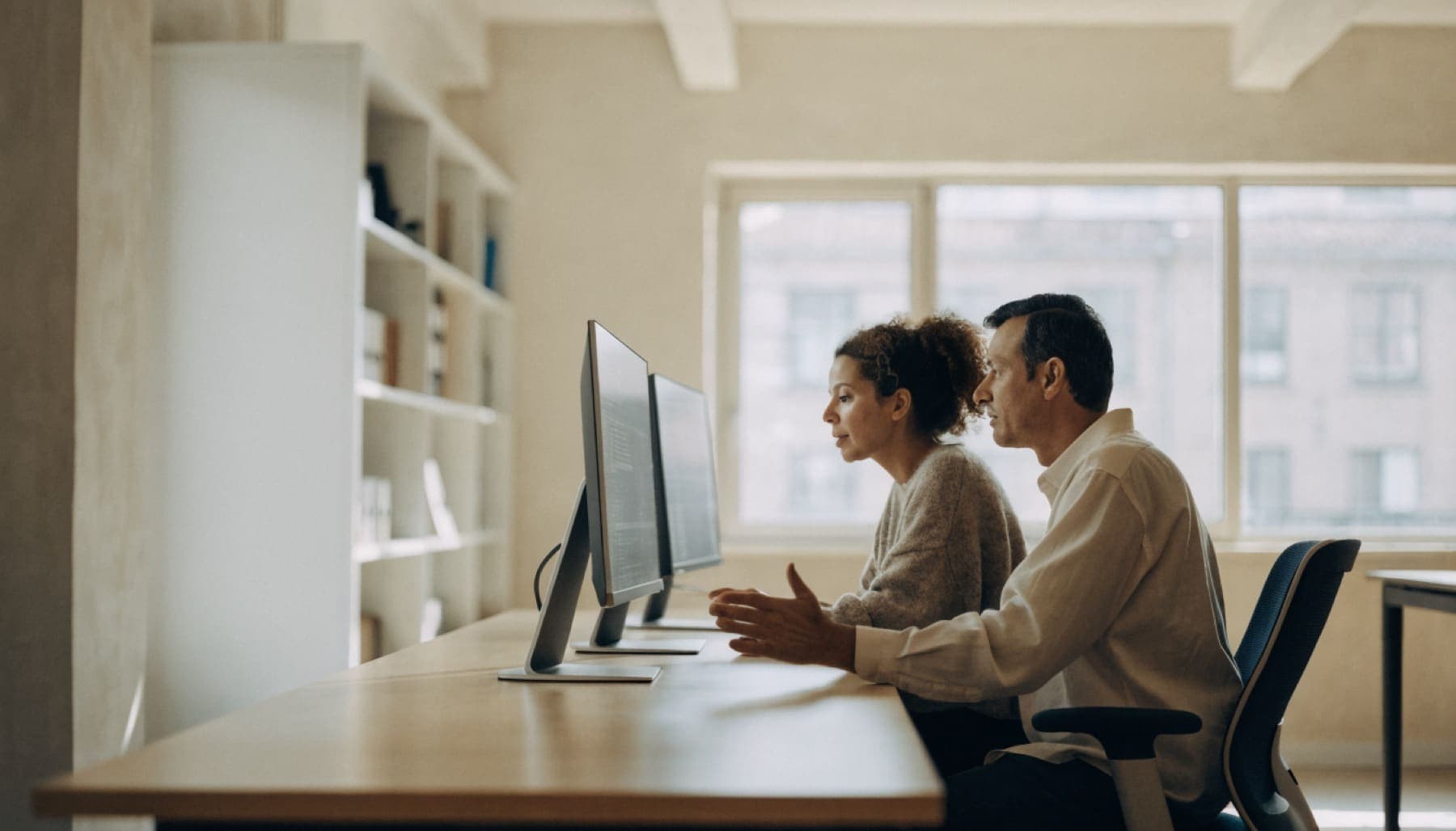 Two developers review code together on two screens