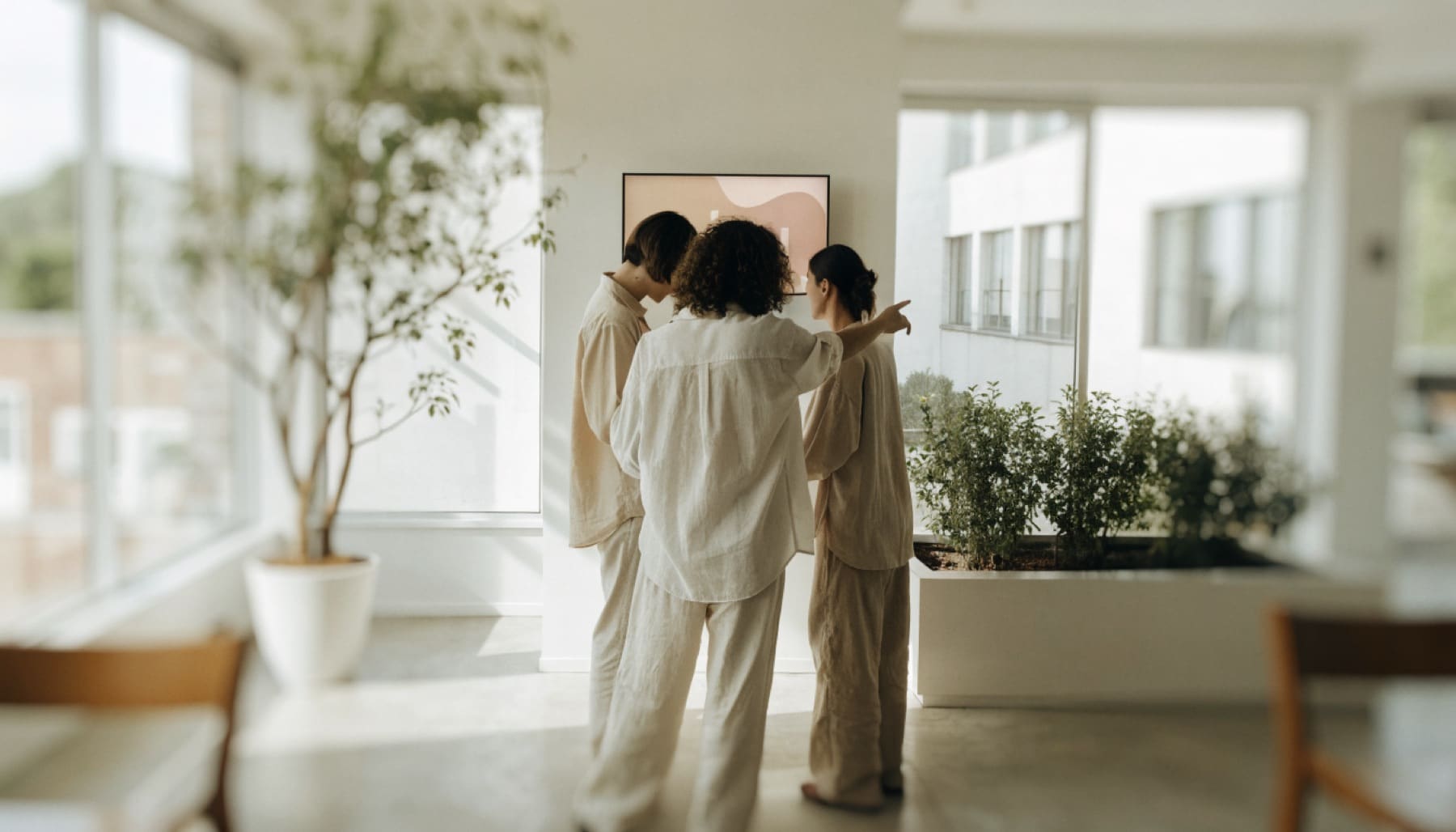 A small operations team reviews progress together on a wall-mounted screen
