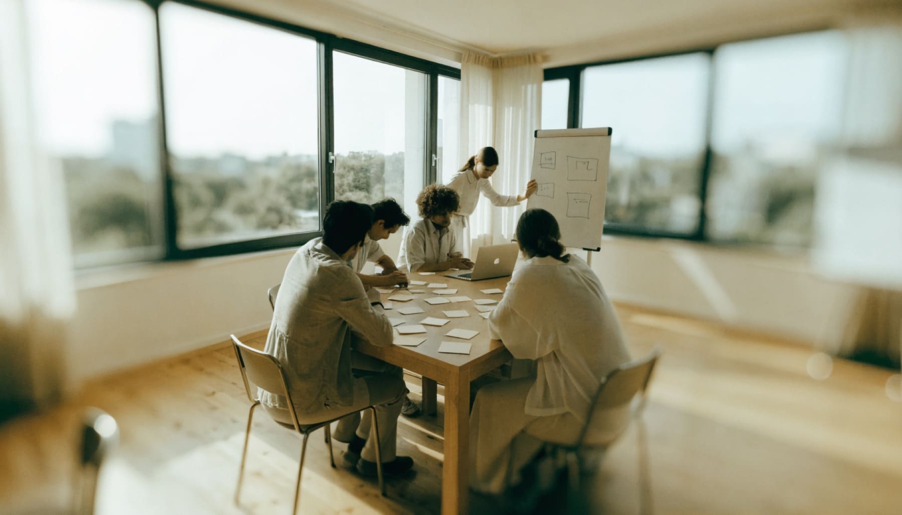 A management team works together at a table covered in sticky notes during an AI workshop