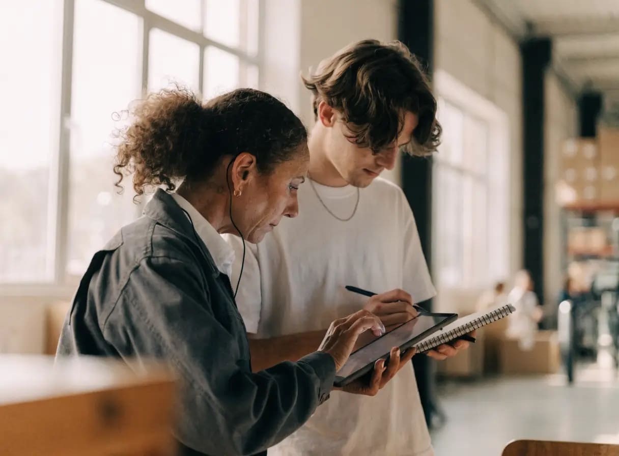 Employee tests a new internal application on a tablet while a developer takes notes